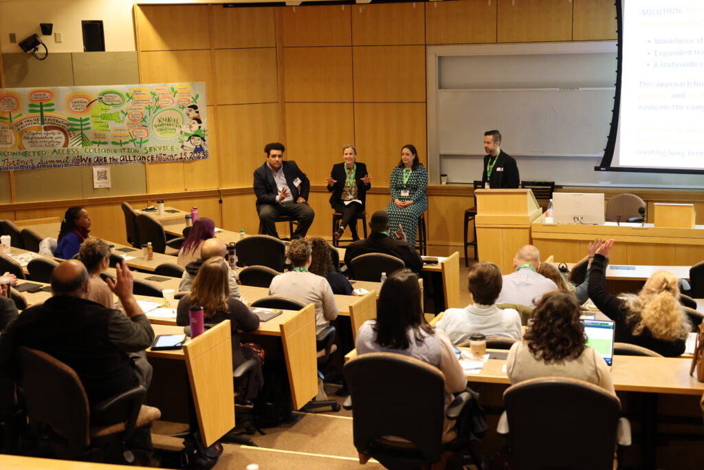 William Medina of Tech Foundry, Jody Jones of the Massachusetts Broadband Institute, and MA State Representative for Hampshire 1 District, Lindsay Sabadosa, speak on a panel moderated by Rich Vaden, Digital Navigator, United Way of Franklin and Hampshire County about the importance of amplifying the work of Digital Navigators in MA.